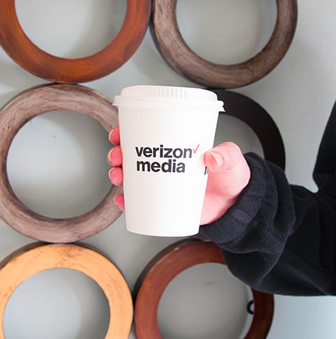 Paper hot cup with "Verizon Media" logo.